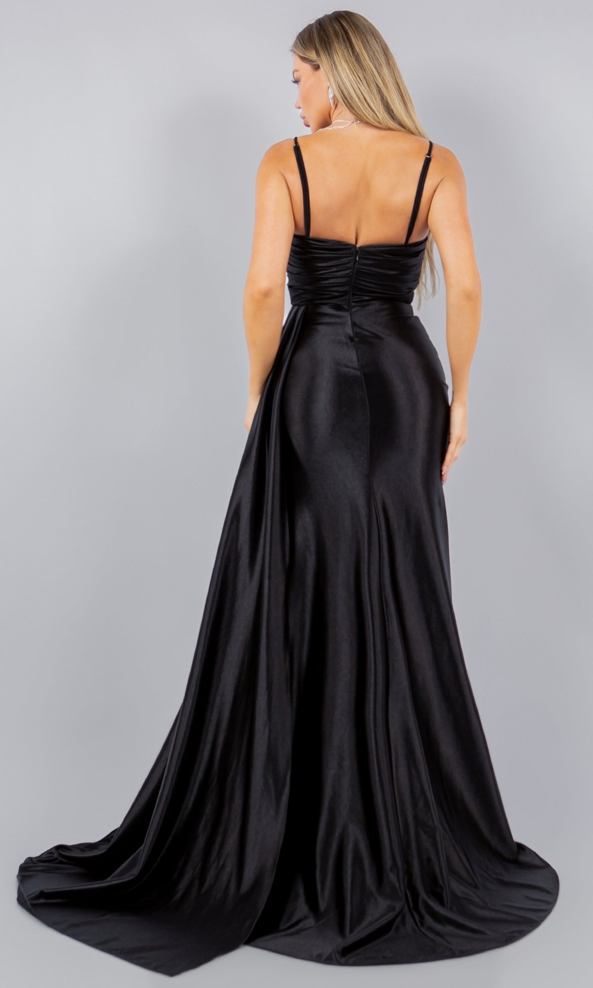 A woman models the Strapless Satin Prom Dress: Cinderella Couture 8082J, a long black evening gown, shown from the back against a plain gray background.